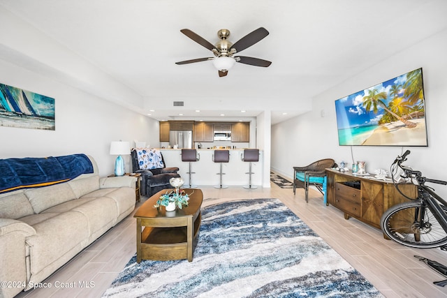 living room featuring light hardwood / wood-style floors and ceiling fan