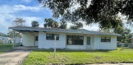 ranch-style home with a front yard and a carport