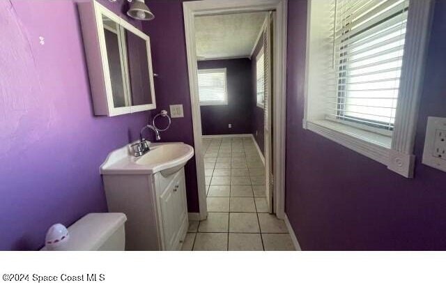 bathroom featuring tile patterned flooring, vanity, and toilet