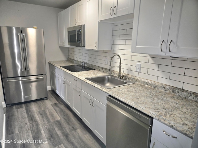 kitchen with dark hardwood / wood-style flooring, tasteful backsplash, stainless steel appliances, sink, and white cabinetry