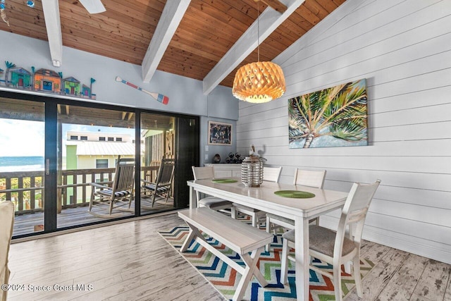 dining area featuring vaulted ceiling with beams, wooden walls, hardwood / wood-style floors, and wood ceiling