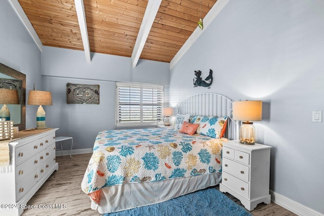 bedroom with vaulted ceiling with beams, light hardwood / wood-style flooring, and wood ceiling