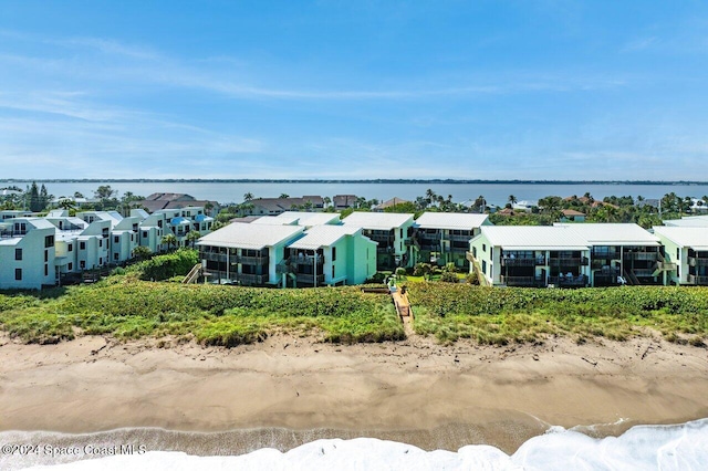 drone / aerial view with a water view and a beach view