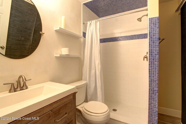 bathroom featuring vanity, hardwood / wood-style floors, a shower with shower curtain, and toilet