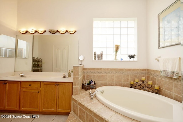 bathroom featuring tile patterned floors, vanity, and tiled tub