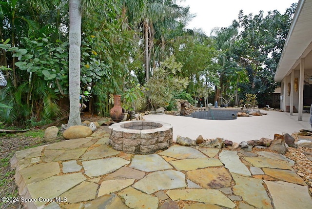 view of patio / terrace featuring a pool and an outdoor fire pit