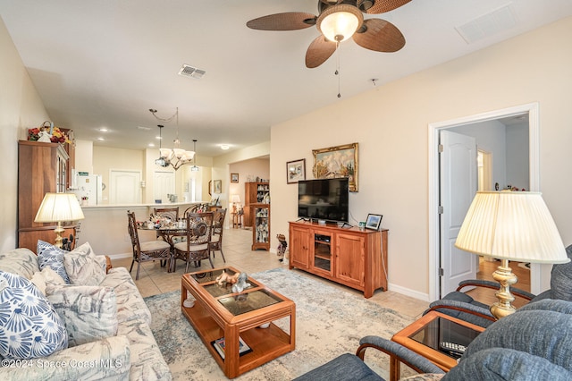 tiled living room featuring ceiling fan with notable chandelier