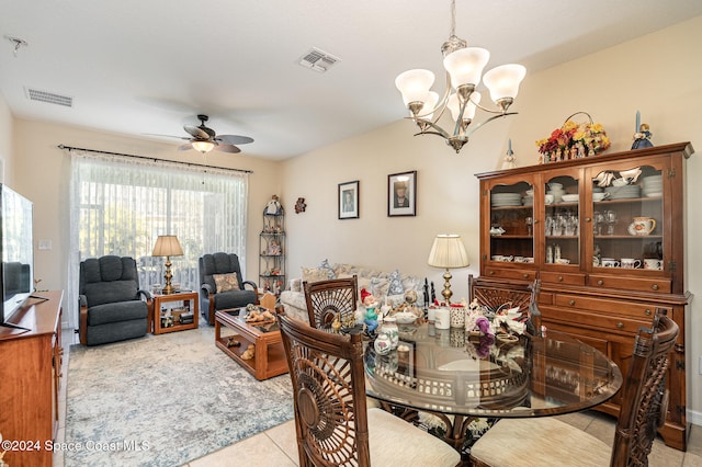 dining space with light tile patterned floors and ceiling fan with notable chandelier