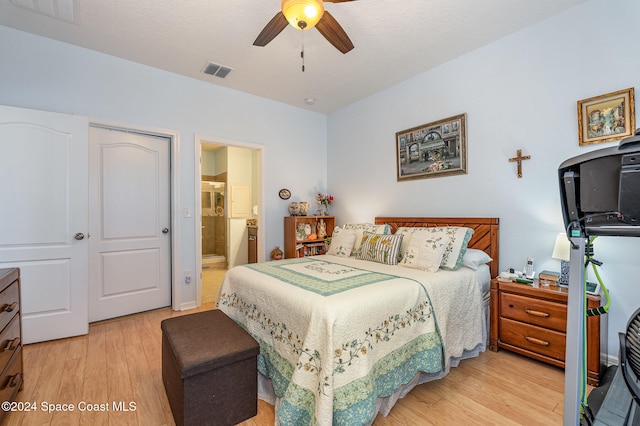 bedroom featuring ensuite bath, ceiling fan, a textured ceiling, a closet, and light wood-type flooring