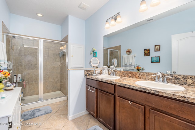 bathroom with tile patterned flooring, vanity, and an enclosed shower