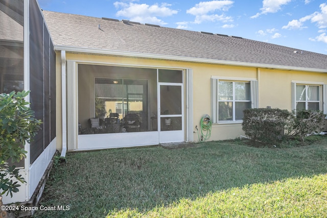 back of house with a sunroom and a yard