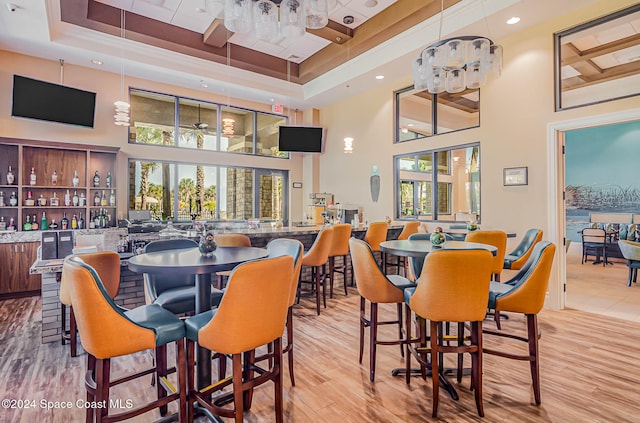 dining area featuring a raised ceiling, a wealth of natural light, and a high ceiling