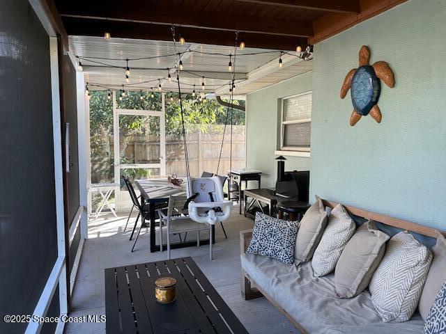 sunroom featuring beam ceiling, rail lighting, and wood ceiling