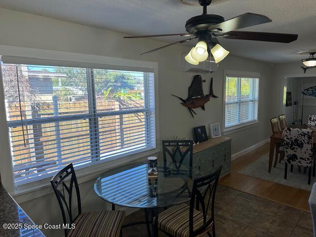 dining room featuring a textured ceiling, tile patterned floors, a wealth of natural light, and ceiling fan