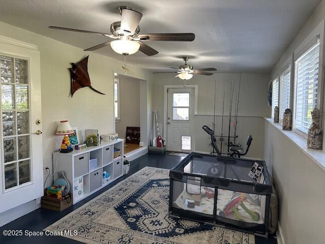 living room with ceiling fan and plenty of natural light