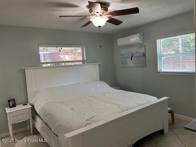 tiled bedroom featuring a textured ceiling, a wall mounted AC, and ceiling fan