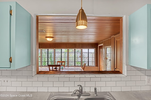 kitchen with decorative backsplash, sink, and hanging light fixtures