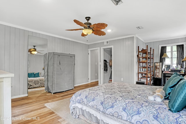 bedroom with light hardwood / wood-style flooring, ceiling fan, and ornamental molding