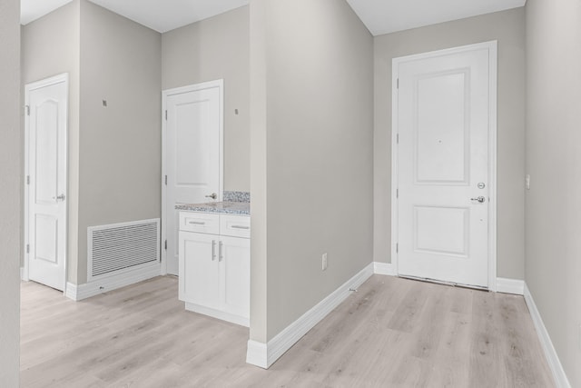 hallway with light hardwood / wood-style floors