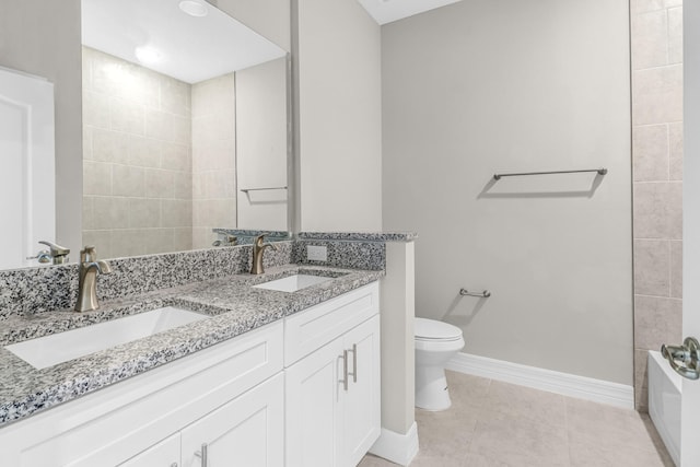 bathroom with toilet, vanity, and tile patterned floors