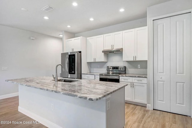 kitchen featuring a center island with sink, white cabinetry, stainless steel appliances, and light hardwood / wood-style flooring