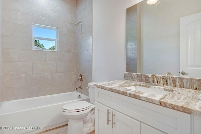 full bathroom with vanity, tiled shower / bath combo, hardwood / wood-style flooring, and toilet