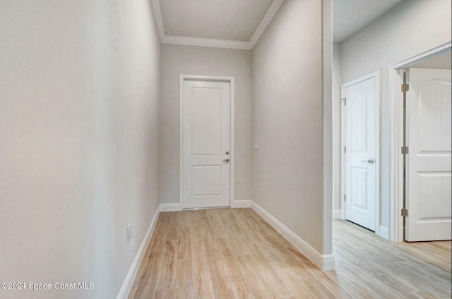 hall featuring crown molding and light hardwood / wood-style flooring