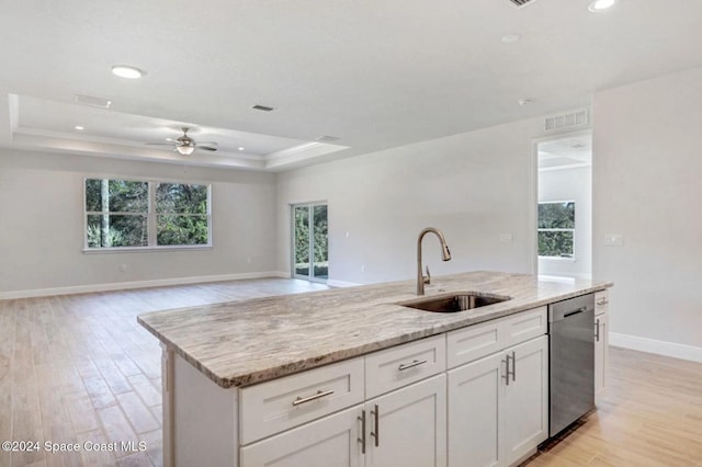 kitchen featuring white cabinets, a kitchen island with sink, sink, dishwasher, and light hardwood / wood-style floors