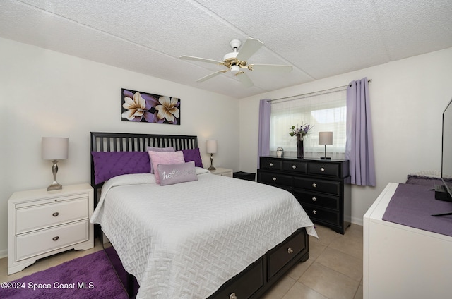 tiled bedroom featuring ceiling fan and a textured ceiling