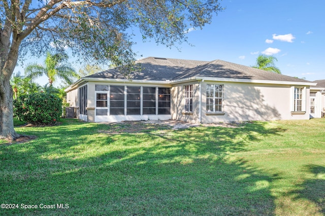 rear view of house featuring a sunroom and a yard