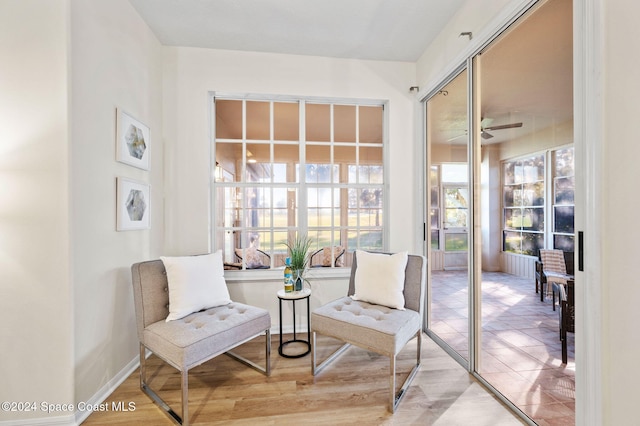 living area featuring wood-type flooring and ceiling fan