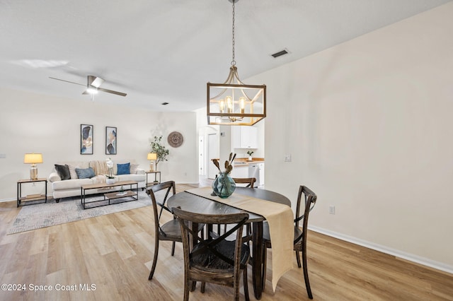 dining area featuring ceiling fan with notable chandelier and light wood-type flooring