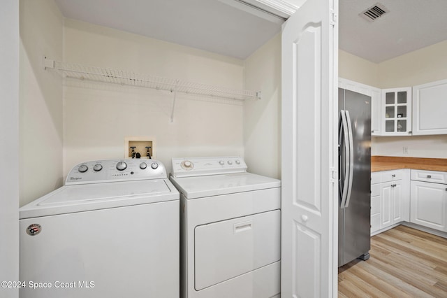 laundry room featuring light hardwood / wood-style floors and washing machine and dryer