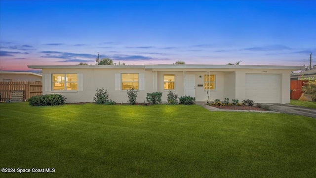 ranch-style house featuring a yard and a garage