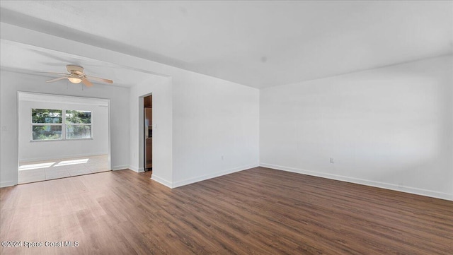 unfurnished room with ceiling fan and dark wood-type flooring