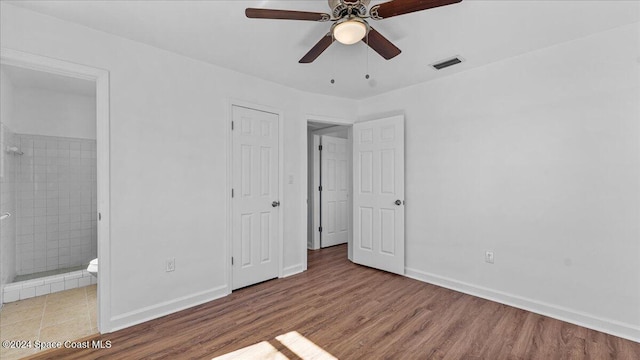 unfurnished bedroom with ensuite bathroom, hardwood / wood-style floors, and ceiling fan