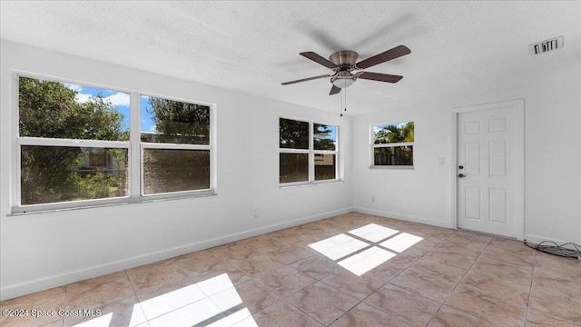 unfurnished room featuring light tile patterned floors, a textured ceiling, and ceiling fan