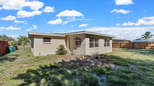 back of property featuring a lawn