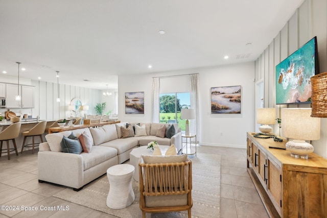 tiled living room featuring a chandelier