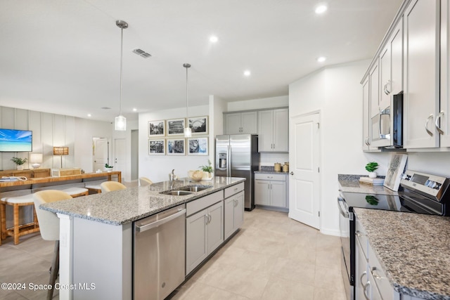 kitchen featuring sink, an island with sink, stainless steel appliances, and decorative light fixtures