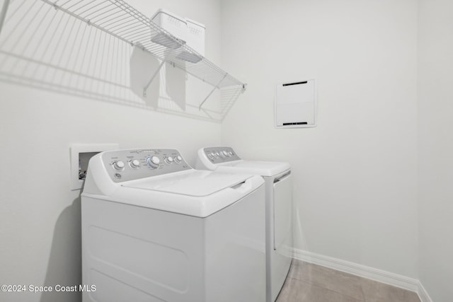 washroom featuring light tile patterned floors and washing machine and clothes dryer