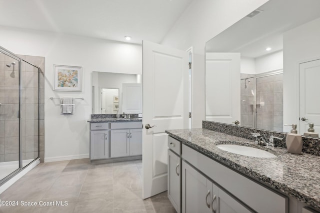 bathroom with tile patterned floors, vanity, and a shower with door