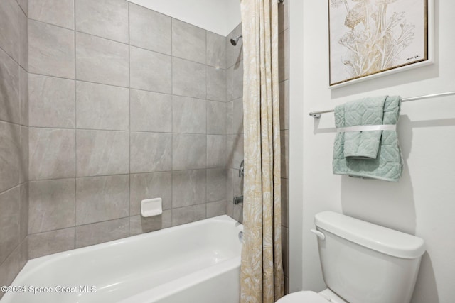 bathroom featuring shower / bath combination with curtain and toilet