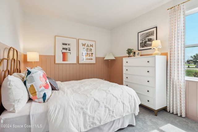 carpeted bedroom with wood walls