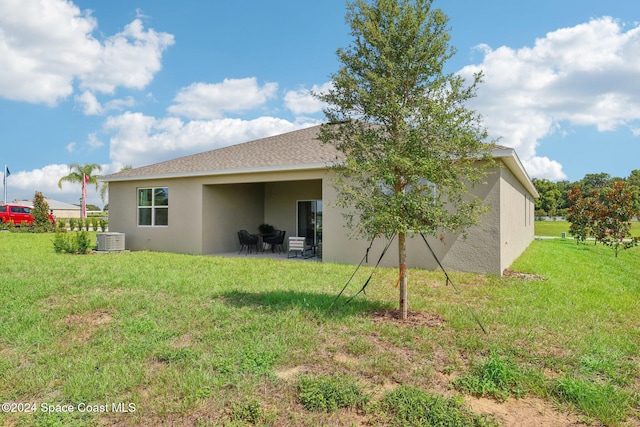 back of property featuring a yard, central AC, and a patio area