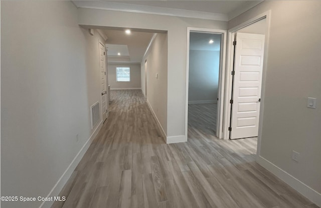 hall featuring crown molding and light hardwood / wood-style floors