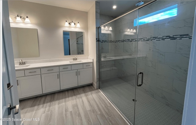 bathroom featuring hardwood / wood-style flooring, vanity, and walk in shower