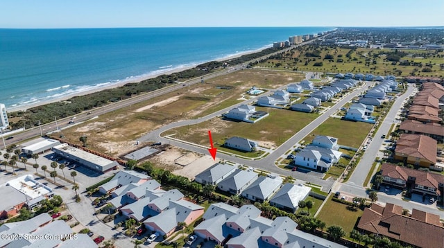 drone / aerial view with a beach view and a water view