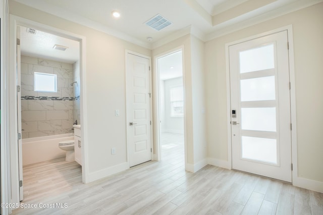 entrance foyer with ornamental molding and light wood-type flooring