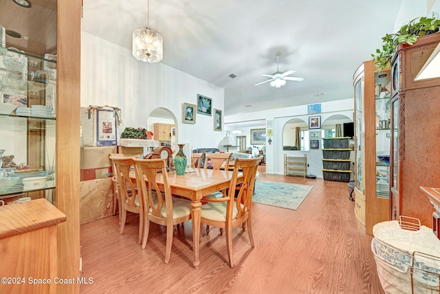 dining room with ceiling fan with notable chandelier and light hardwood / wood-style flooring